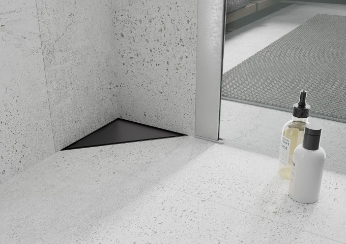 Svart golvbrunn i grått badrum